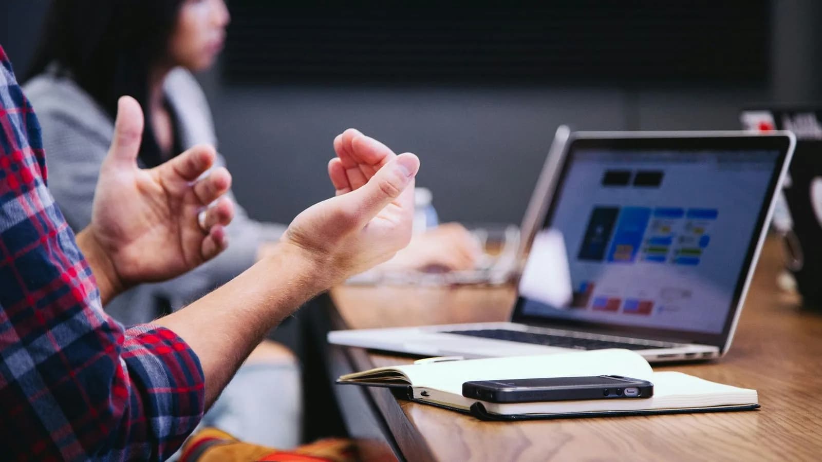 A business discussion around a laptop and notebooks. Illustrative photo.